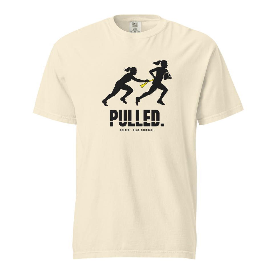 Ivory Pulled Tee, front: black silhouette of one player pulling a yellow flag from another, PULLED. below